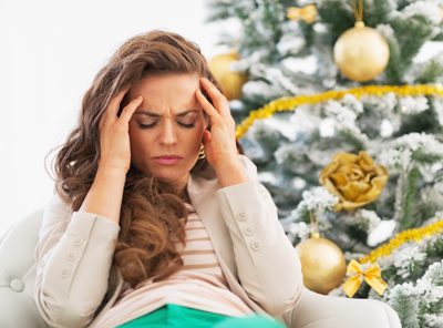 how to cope with stress during the holidays - woman stressed sitting next to christmas tree - victory addiction recovery center