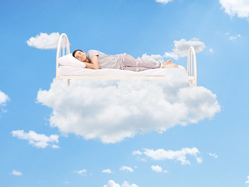 The Importance of Sleep in Recovery - man sleeping on bed in clouds