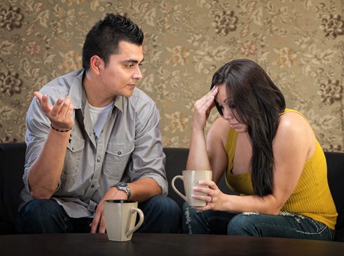 What Not to Do When Someone Comes Home from Rehab - man and woman drinking coffee disagreeing