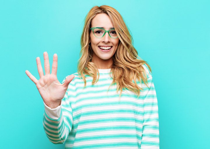 pretty blonde young woman in glasses holding her hand out to symbol the number five - alumni program